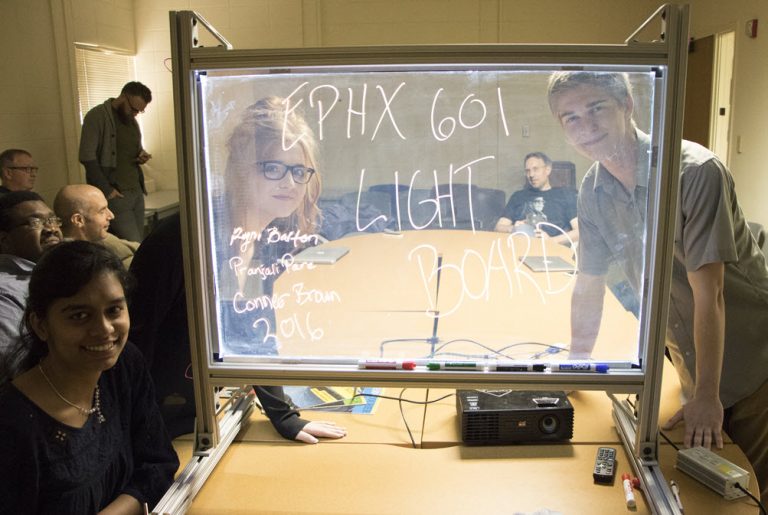 3 people posing through a lightboard for a photo 