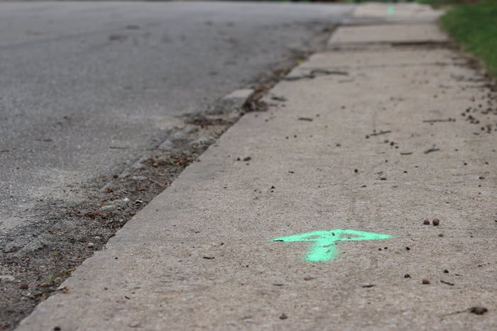 green arrow spray painted on the sidewalk