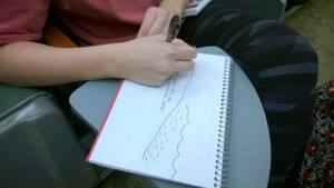 student drawing on a notebook