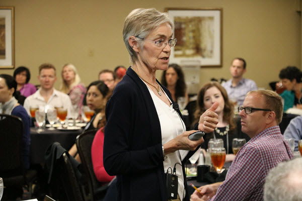 A woman speaking to a crowd at a conference
