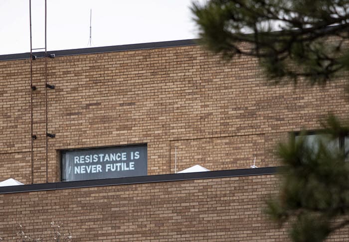 A sign saying 'Resistance is never futile' seen in the window of chalmers hall
