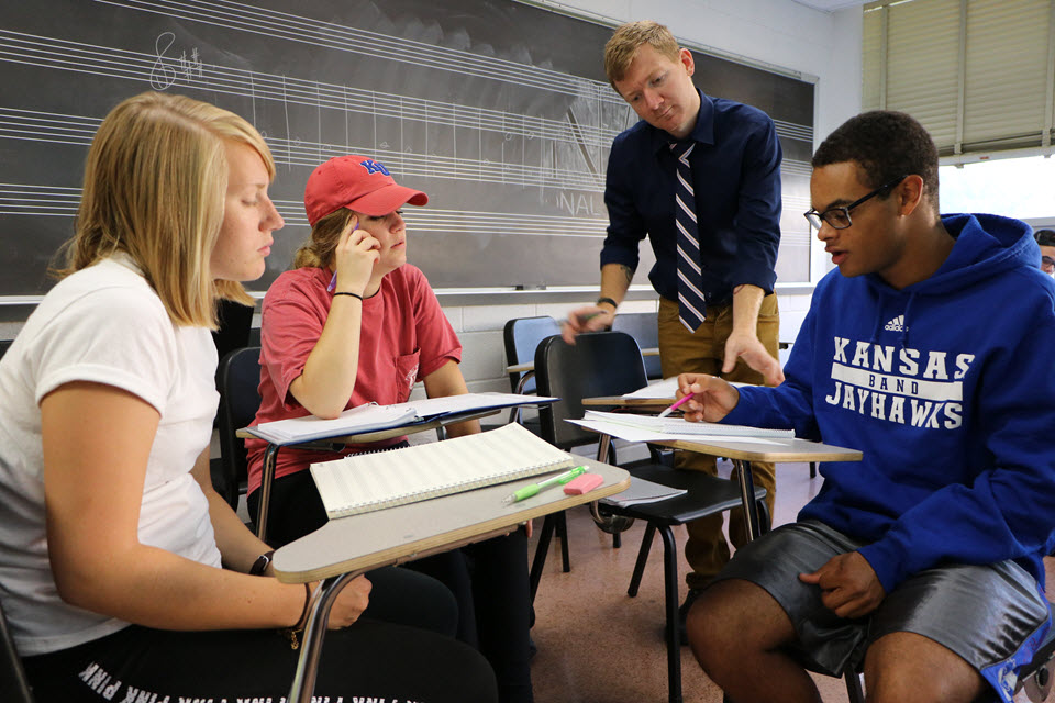 Brad Osborne teaching three students sitting in desks