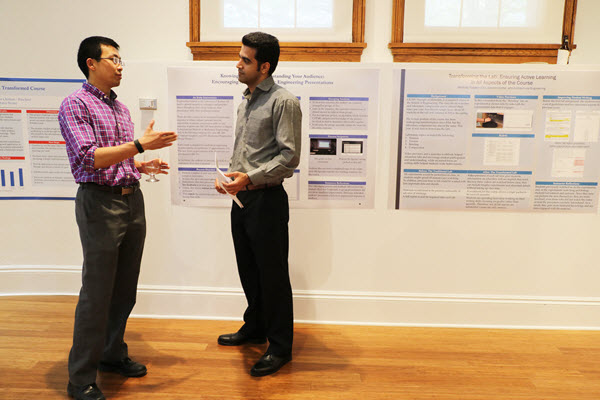 Xianglin Li and Moein Moradi talking in front of posters