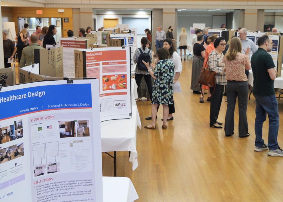 Crowd of people looking at academic posters in a ballroom