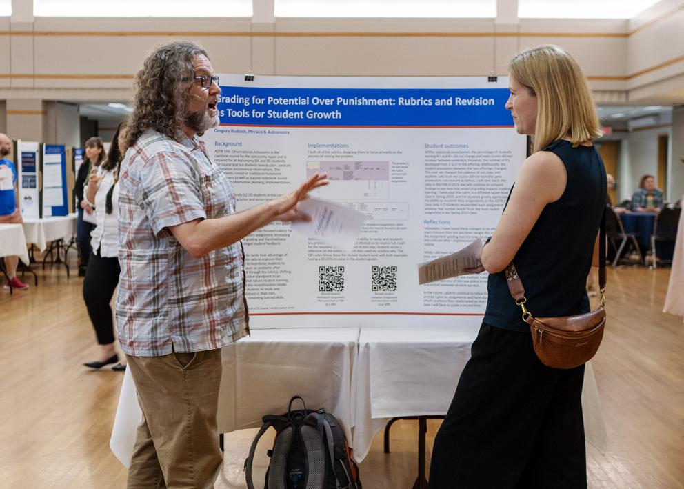 Poster presenter speaks with visitor with academic poster