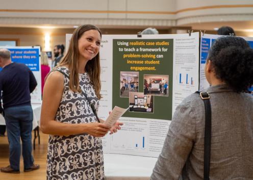 KU faculty member speaks to other faculty about academic poster