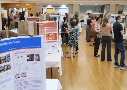 Crowd of people looking at academic posters in a ballroom